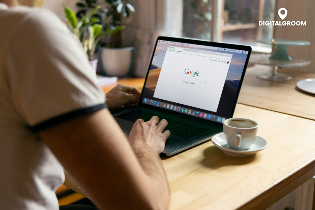 Person bei der Nutzung von Google-Suche auf einem Laptop mit einer Tasse Kaffee auf dem Schreibtisch, digitales Marketing im Homeoffice-Konzept